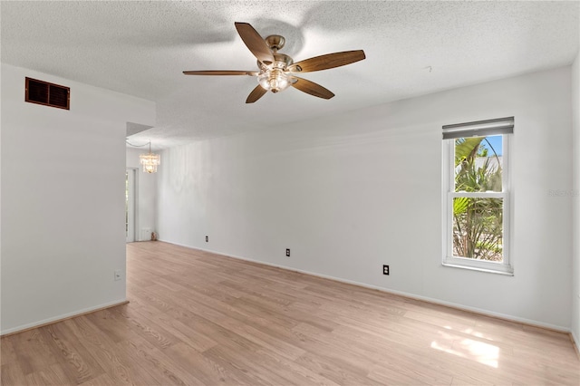 441 75th Ave N, Saint Petersburg, FL 33702 - unfurnished room with ceiling fan, a chandelier, light wood-type flooring, and a textured ceiling