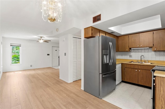 441 75th Ave N, Saint Petersburg, FL 33702 - kitchen with stainless steel fridge, white dishwasher, light countertops, decorative backsplash, and electric stove