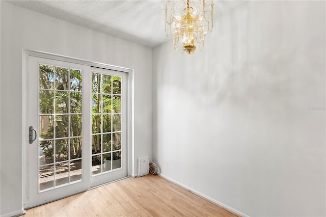 441 75th Ave N, Saint Petersburg, FL 33702 - doorway to outside featuring wood finished floors, a chandelier, and a textured ceiling