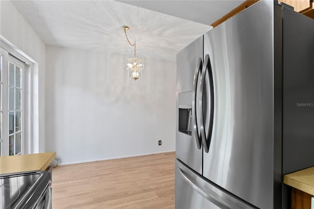 441 75th Ave N, Saint Petersburg, FL 33702 - kitchen with stainless steel appliances, light wood-style flooring, a chandelier, a textured ceiling, and pendant lighting