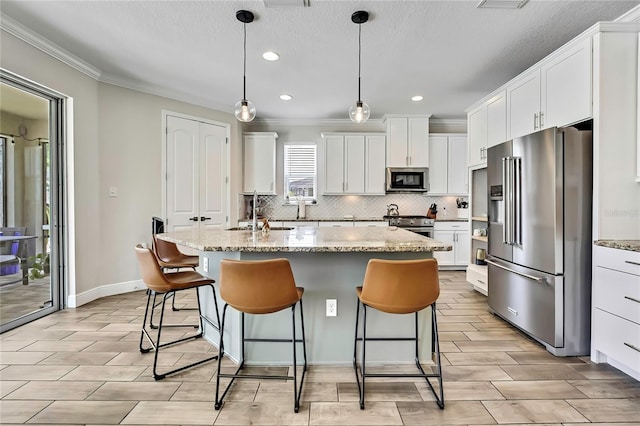 1669 Feather Grass Loop, Lutz, FL 33558 - kitchen with high quality appliances, ornamental molding, wood tiled floors, tasteful backsplash, and white cabinets