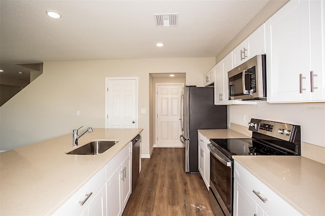 1229 Tidal St, Haines City, FL 33844 - kitchen featuring stainless steel appliances, dark wood-type flooring, white cabinets, light countertops, and recessed lighting