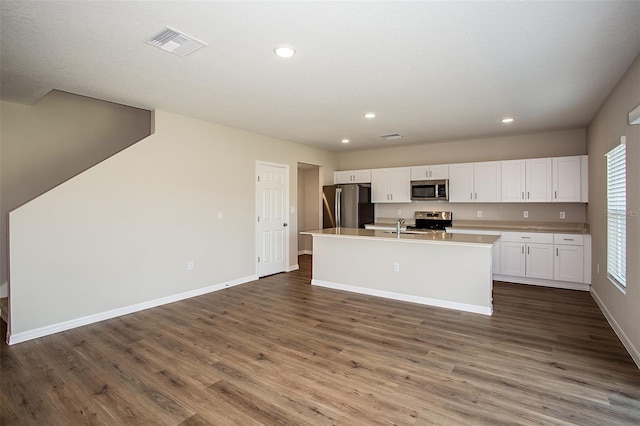 1229 Tidal St, Haines City, FL 33844 - kitchen featuring stainless steel appliances, white cabinetry, dark wood-style flooring, an island with sink, and recessed lighting