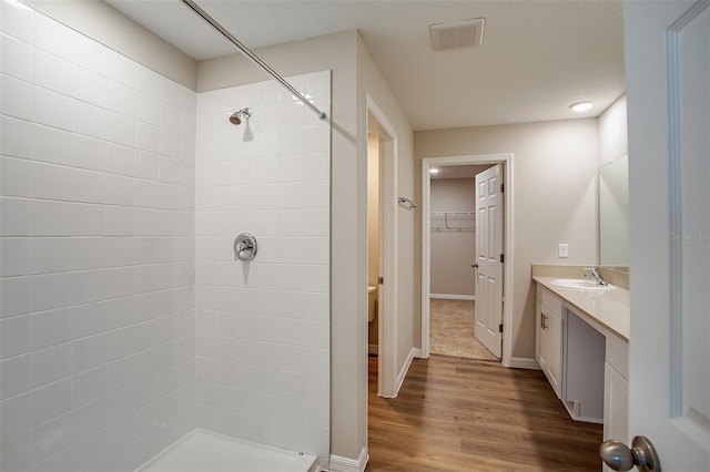 1229 Tidal St, Haines City, FL 33844 - full bathroom featuring vanity, tiled shower, wood finished floors, and a walk in closet