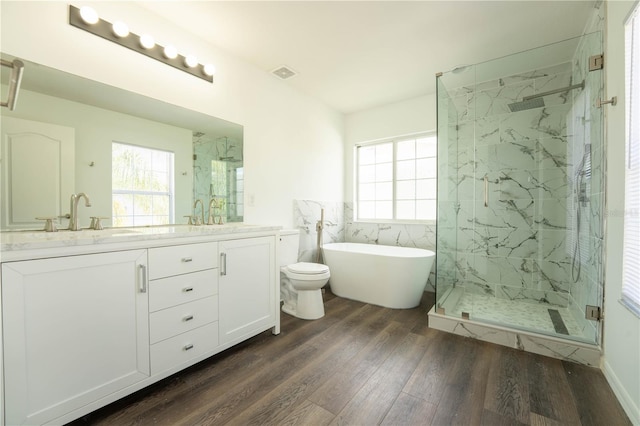 9110 Lantern Oak Way, Land O Lakes, FL 34638 - full bathroom featuring wood finished floors, a marble finish shower, double vanity, a freestanding tub, and tile walls