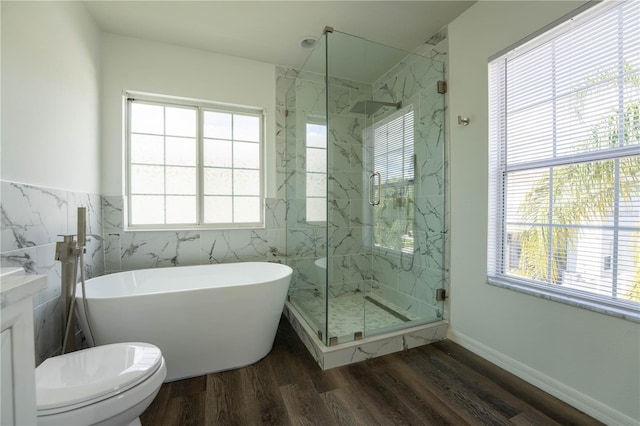 9110 Lantern Oak Way, Land O Lakes, FL 34638 - bathroom featuring a freestanding tub, tile walls, wood finished floors, a marble finish shower, and wainscoting