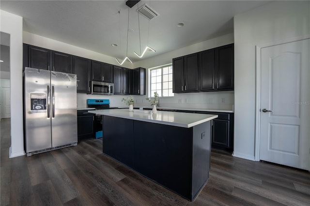 9110 Lantern Oak Way, Land O Lakes, FL 34638 - kitchen with stainless steel appliances, dark wood-style flooring, dark cabinets, light countertops, and a center island