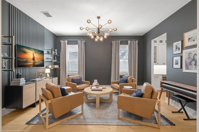 4114 W Neptune St, Tampa, FL 33629 - living area featuring light wood finished floors, a chandelier, and a textured ceiling