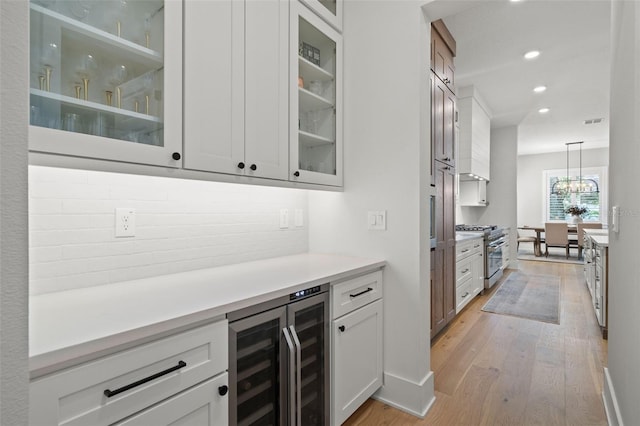 4114 W Neptune St, Tampa, FL 33629 - bar area with wine cooler, high end stainless steel range oven, light wood-style flooring, pendant lighting, and recessed lighting