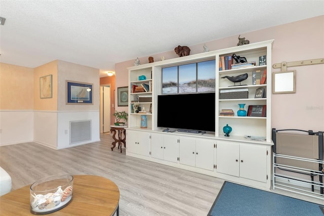 6025 Shore Blvd S Unit 408, Gulfport, FL 33707 - living room featuring light wood-style flooring and a textured ceiling