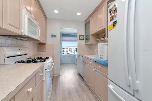 6025 Shore Blvd S Unit 408, Gulfport, FL 33707 - kitchen with white appliances, light wood finished floors, light countertops, glass insert cabinets, and recessed lighting