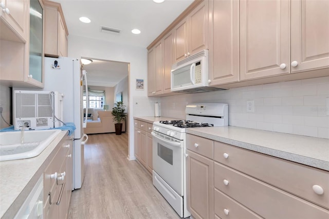 6025 Shore Blvd S Unit 408, Gulfport, FL 33707 - kitchen featuring white appliances, light wood-type flooring, light countertops, decorative backsplash, and recessed lighting