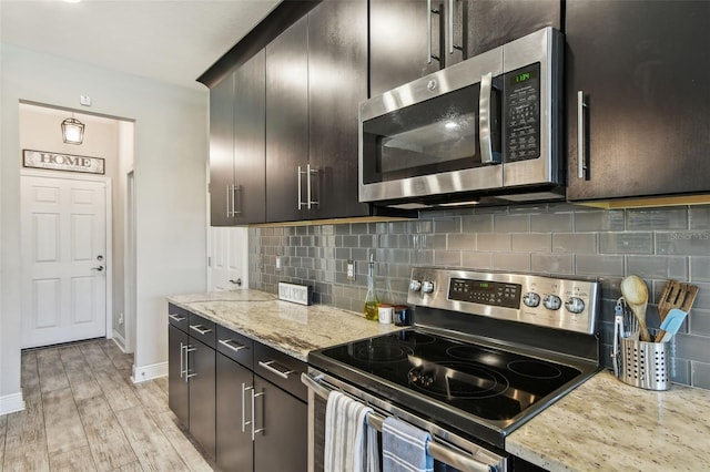 11519 Crowned Sparrow Ln, Tampa, FL 33626 - kitchen with stainless steel appliances, backsplash, light stone counters, and light wood-style flooring
