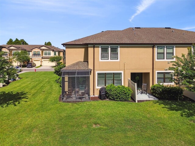 11519 Crowned Sparrow Ln, Tampa, FL 33626 - back of property with stucco siding, a lawn, a sunroom, and a shingled roof