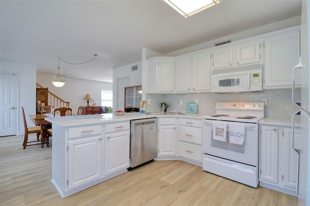 408 Georgia Ave, Crystal Beach, FL 34681 - kitchen featuring white appliances, a peninsula, light countertops, and decorative backsplash