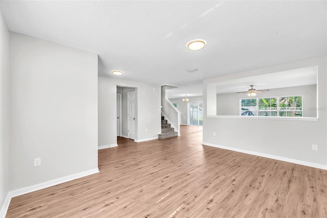 10523 Boyette Creek Blvd, Riverview, FL 33569 - spare room featuring wood finished floors, stairway, a ceiling fan, and a chandelier