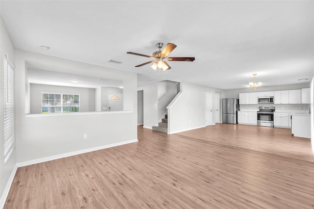 10523 Boyette Creek Blvd, Riverview, FL 33569 - unfurnished living room with a chandelier, light wood-type flooring, stairway, and ceiling fan