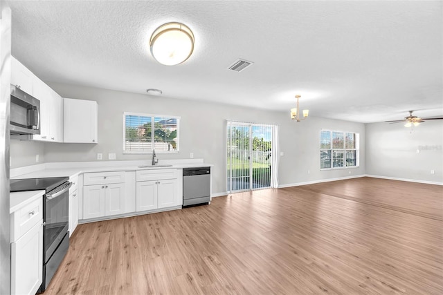 10523 Boyette Creek Blvd, Riverview, FL 33569 - kitchen featuring stainless steel appliances, light wood-style flooring, healthy amount of natural light, open floor plan, and a textured ceiling