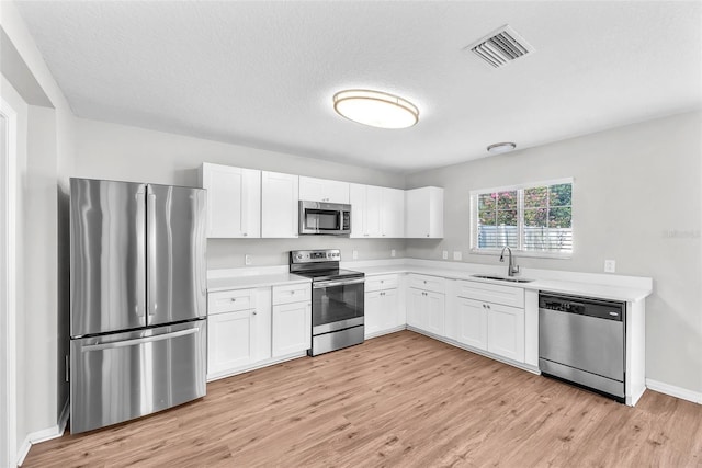 10523 Boyette Creek Blvd, Riverview, FL 33569 - kitchen featuring appliances with stainless steel finishes, light countertops, white cabinetry, and light wood-style floors