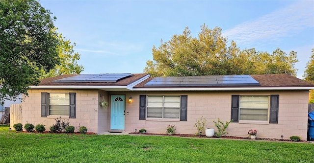 1841 Talmadge St, Deland, FL 32724 - ranch-style home with a front lawn, roof with shingles, and roof mounted solar panels