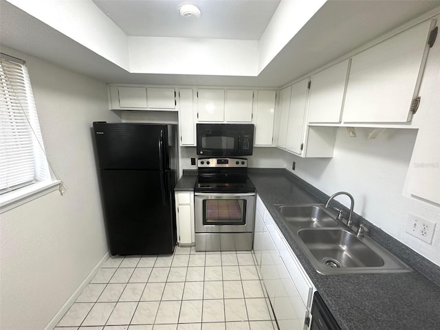 6342 Newtown Cir Unit A4, Tampa, FL 33615 - kitchen with black appliances, dark countertops, white cabinets, a raised ceiling, and light tile patterned flooring
