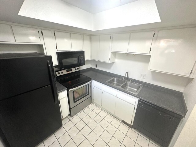 6342 Newtown Cir Unit A4, Tampa, FL 33615 - kitchen featuring black appliances, dark countertops, light tile patterned floors, and white cabinetry