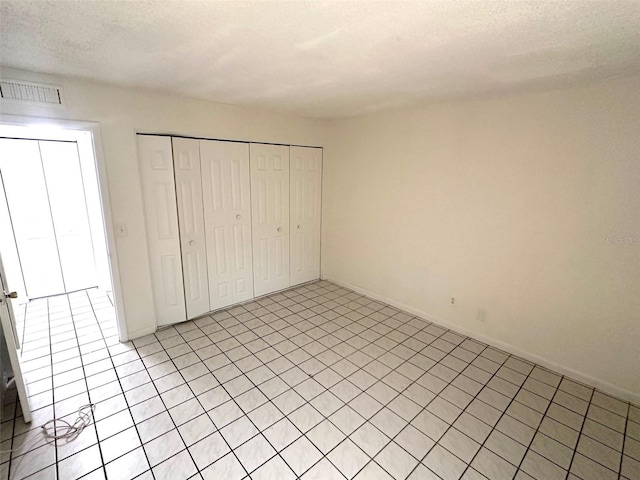 6342 Newtown Cir Unit A4, Tampa, FL 33615 - unfurnished bedroom featuring a closet, light tile patterned floors, and a textured ceiling