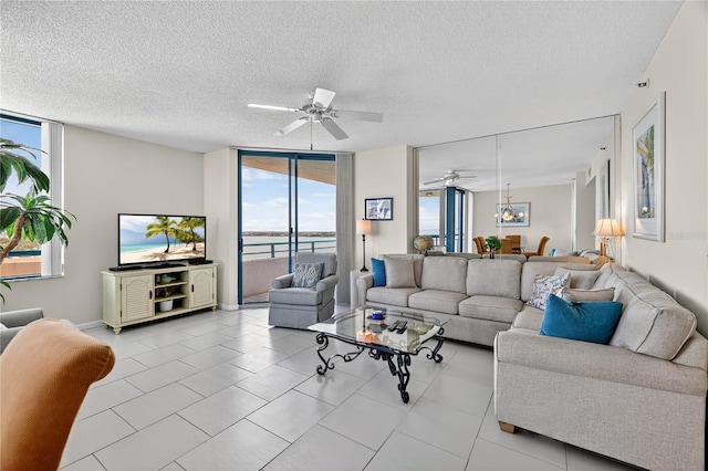 1540 Gulf Blvd Unit 2107, Clearwater Beach, FL 33767 - living room featuring plenty of natural light, a ceiling fan, expansive windows, a textured ceiling, and light tile patterned floors