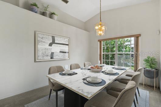 1741 Elk Spring Dr, Brandon, FL 33511 - carpeted dining space with a chandelier and high vaulted ceiling