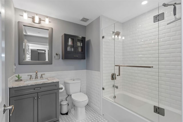 1108 N Franklin St Unit 602, Tampa, FL 33602 - bathroom featuring vanity, tile patterned floors, combined bath / shower with glass door, tile walls, and wainscoting
