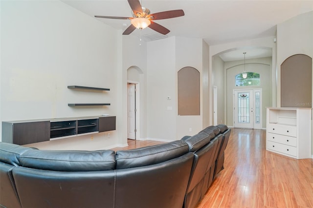 12721 Avelar Creek Dr, Riverview, FL 33578 - living area with arched walkways, light wood-style flooring, and a ceiling fan