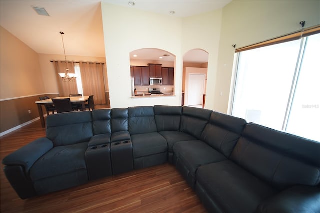 12721 Avelar Creek Dr, Riverview, FL 33578 - living area featuring lofted ceiling, dark wood-style floors, a chandelier, and arched walkways