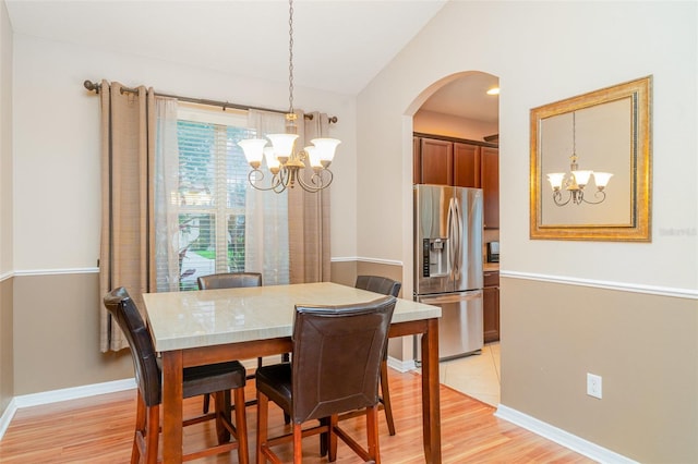 12721 Avelar Creek Dr, Riverview, FL 33578 - dining area featuring a chandelier, light wood-style flooring, and arched walkways