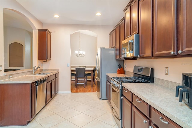12721 Avelar Creek Dr, Riverview, FL 33578 - kitchen with stainless steel appliances, arched walkways, light countertops, a chandelier, and recessed lighting