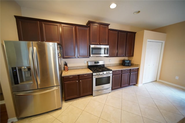 12721 Avelar Creek Dr, Riverview, FL 33578 - kitchen featuring appliances with stainless steel finishes, light countertops, light tile patterned floors, recessed lighting, and dark brown cabinetry