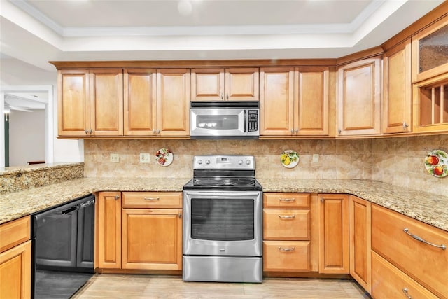 910 Kingscote Ct, Safety Harbor, FL 34695 - kitchen featuring appliances with stainless steel finishes, light wood-style flooring, a raised ceiling, ornamental molding, and light stone countertops