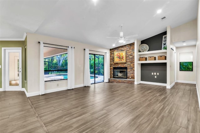 910 Kingscote Ct, Safety Harbor, FL 34695 - unfurnished living room featuring a ceiling fan, vaulted ceiling, wood finished floors, and a fireplace
