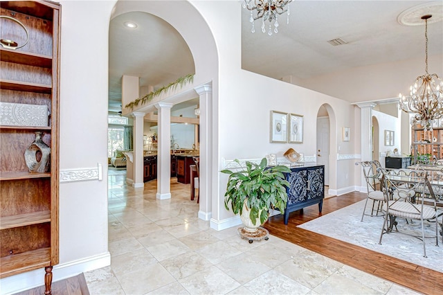 19307 Wind Dancer St, Lutz, FL 33558 - hall featuring a chandelier, arched walkways, and decorative columns