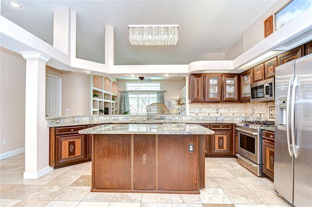19307 Wind Dancer St, Lutz, FL 33558 - kitchen with appliances with stainless steel finishes, a peninsula, light stone countertops, ceiling fan, and glass insert cabinets