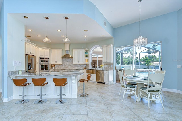 2504 Oak Landing Dr, Brandon, FL 33511 - kitchen featuring stainless steel appliances, tasteful backsplash, a peninsula, light stone countertops, and a breakfast bar area