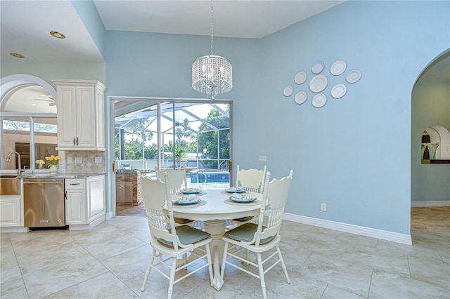 2504 Oak Landing Dr, Brandon, FL 33511 - dining space with arched walkways, a chandelier, a high ceiling, and a sunroom