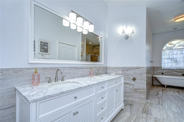 2504 Oak Landing Dr, Brandon, FL 33511 - bathroom featuring tile walls, double vanity, a freestanding bath, a wainscoted wall, and a shower