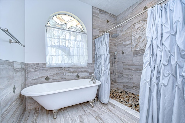2504 Oak Landing Dr, Brandon, FL 33511 - bathroom featuring a freestanding tub, tile walls, tiled shower, and marble finish floors