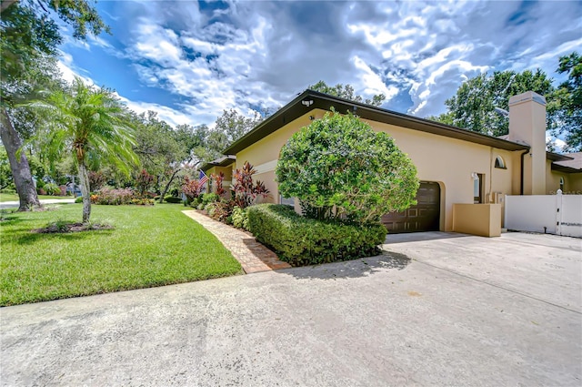 2504 Oak Landing Dr, Brandon, FL 33511 - view of property exterior featuring a garage, stucco siding, driveway, and a chimney