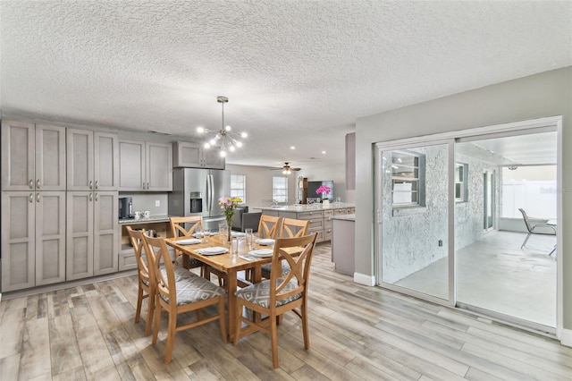 446 Eagle Cir, Casselberry, FL 32707 - dining room featuring light wood-type flooring, a chandelier, and a textured ceiling
