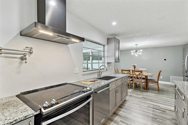 446 Eagle Cir, Casselberry, FL 32707 - kitchen with wall chimney exhaust hood, appliances with stainless steel finishes, gray cabinetry, light wood finished floors, and a textured ceiling
