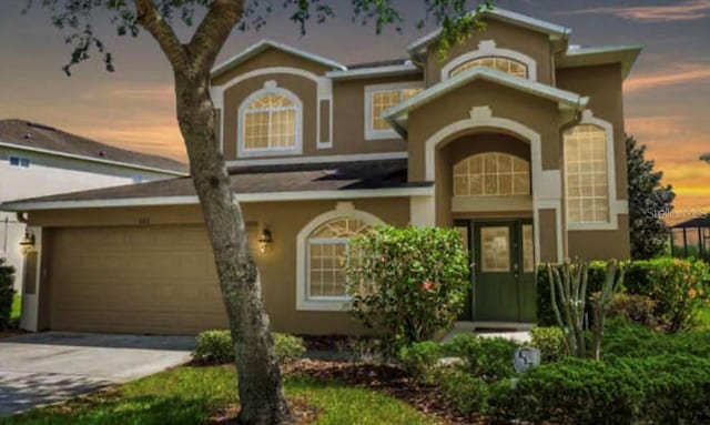 886 Suffolk Pl, Davenport, FL 33896 - view of front of home with stucco siding, driveway, and an attached garage