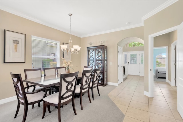 886 Suffolk Pl, Davenport, FL 33896 - dining area with crown molding, a chandelier, light tile patterned floors, arched walkways, and light colored carpet