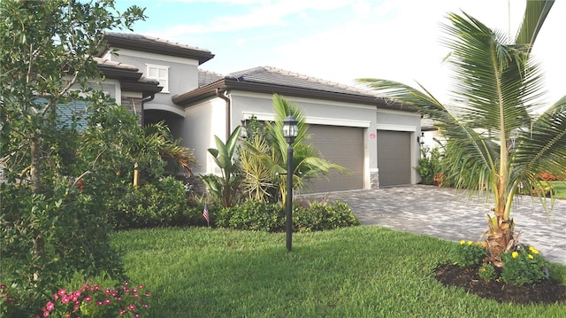 4957 Seafoam Trl, Bradenton, FL 34211 - view of side of home with stucco siding, an attached garage, decorative driveway, a tile roof, and a yard