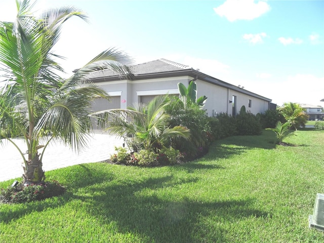 4957 Seafoam Trl, Bradenton, FL 34211 - view of home's exterior featuring stucco siding, a lawn, a garage, and driveway
